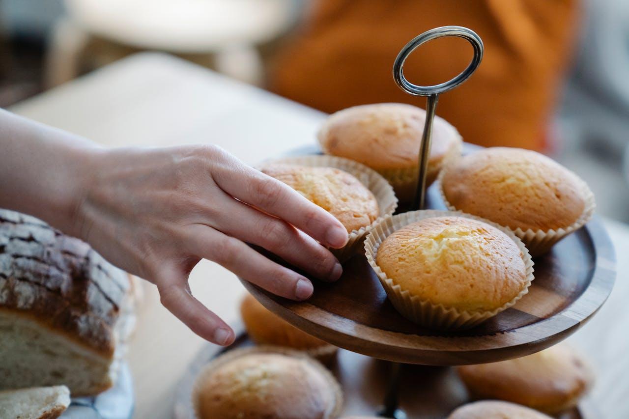 Hand grabs muffins.