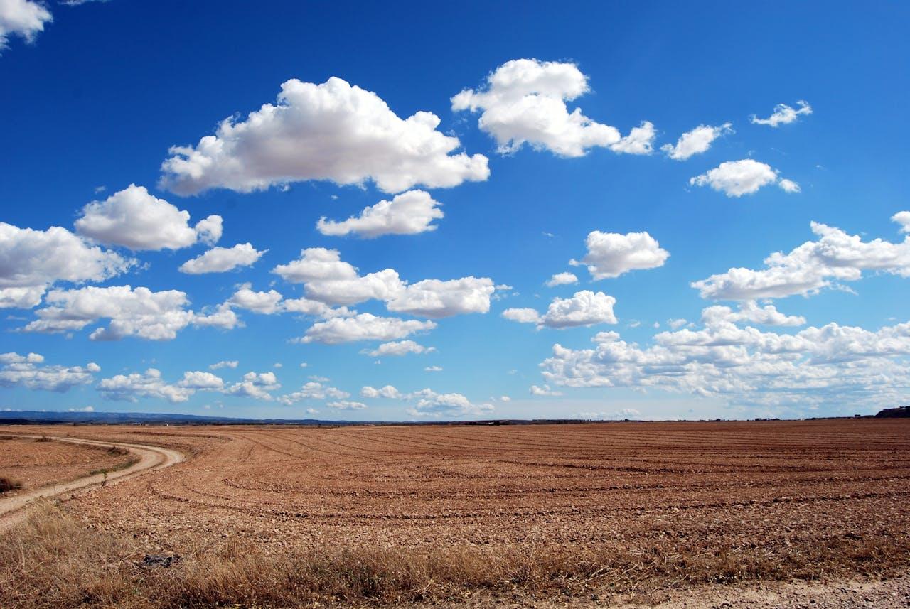 Extensive, barren field under clouds.