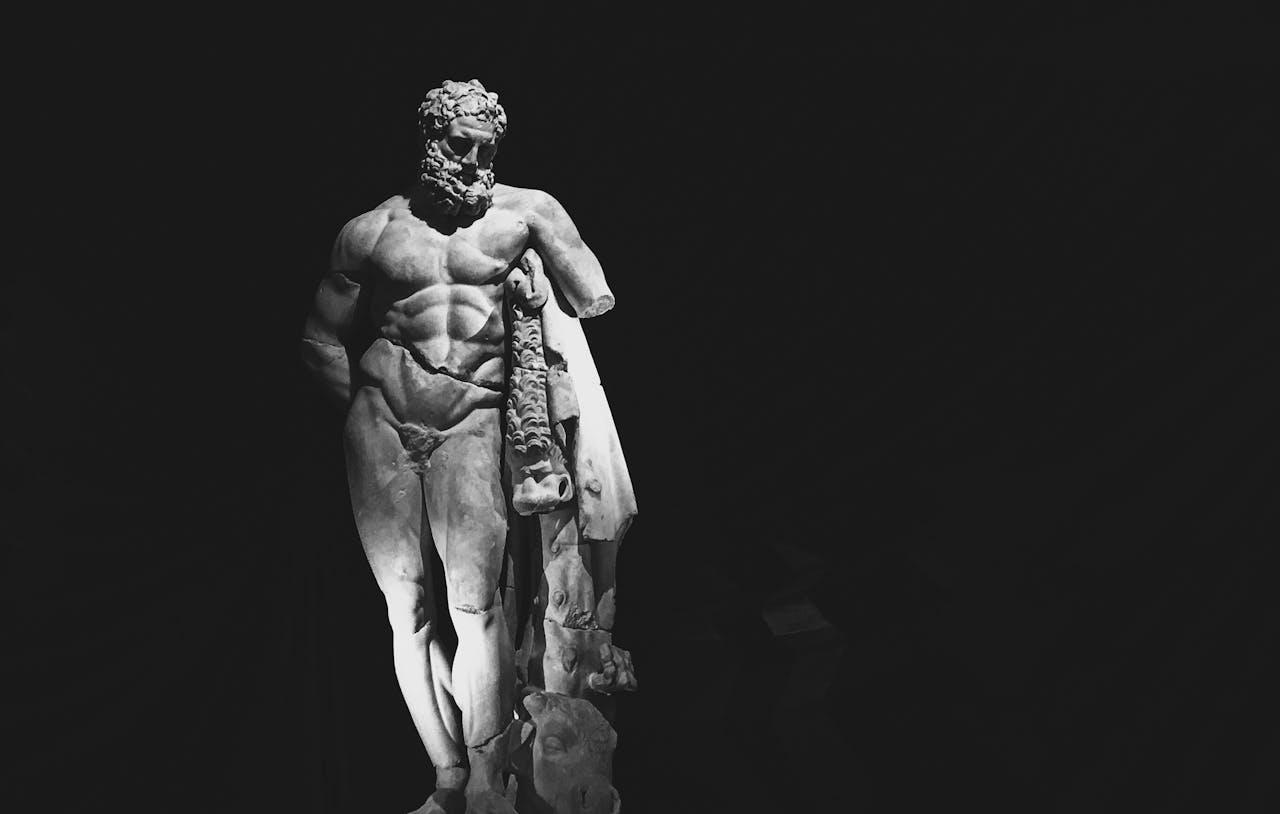 Klassische Stärke im Fokus, eindrucksvolle Statue in dramatischem Licht.
